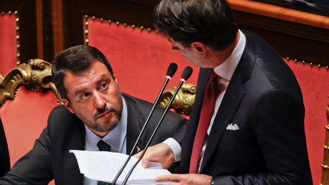 Italian Premier Giuseppe Conte, right, looks at Deputy-Premier Matteo Salvini as he addresses the Senate in Rome, Tuesday, Aug. 20, 2019.