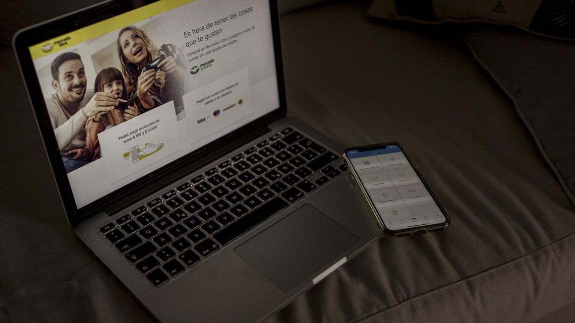 The MercadoLibre MercadoPago application is displayed on an Apple iPhone while the MercadoLibre homepage is shown on a Macbook in an arranged photograph taken in Buenos Aires.