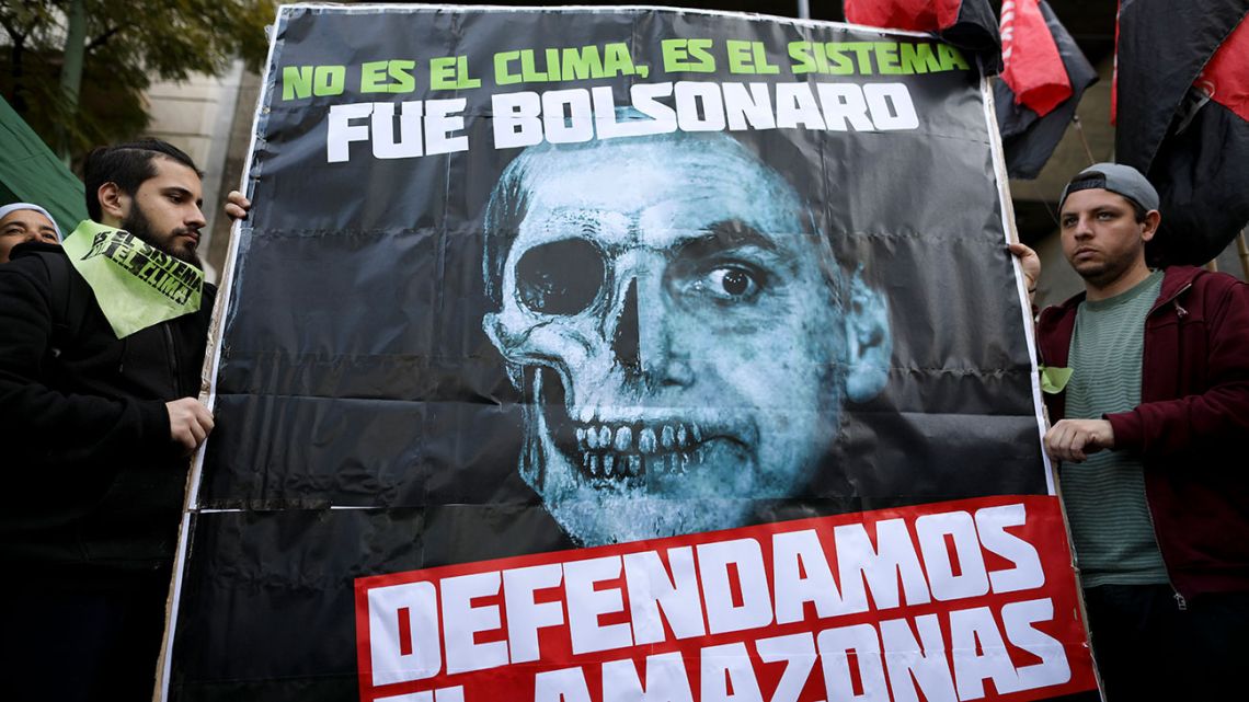 Men hold a sign reading in Spanish 