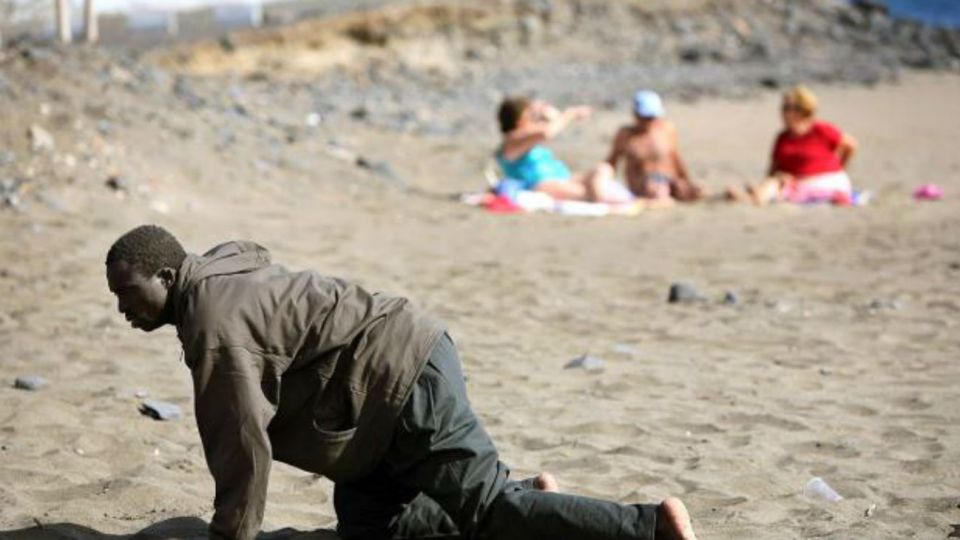 Un migrante africano al llegar a una playa europea.