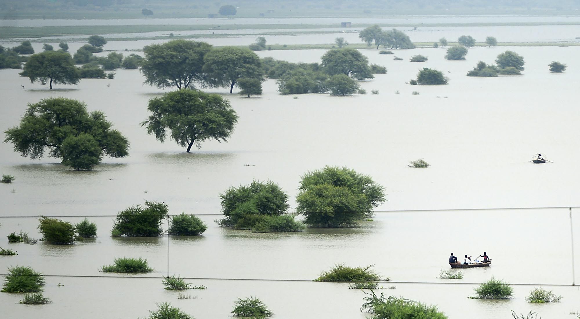 Esta foto de archivo tomada el 21 de agosto de 2019 muestra una vista aérea de aldeanos que usan botes para cruzar el río Ganges inundado a medida que aumentan los niveles de agua en los ríos Ganges y Yamuna, en Allahabad. 