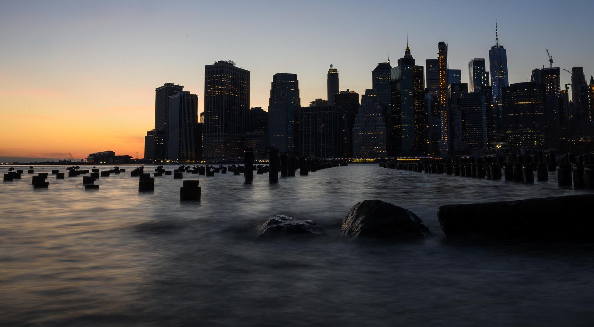 En esta foto de archivo tomada el 7 de abril de 2019, el sol se pone detrás del horizonte del bajo Manhattan en la ciudad de Nueva York. -