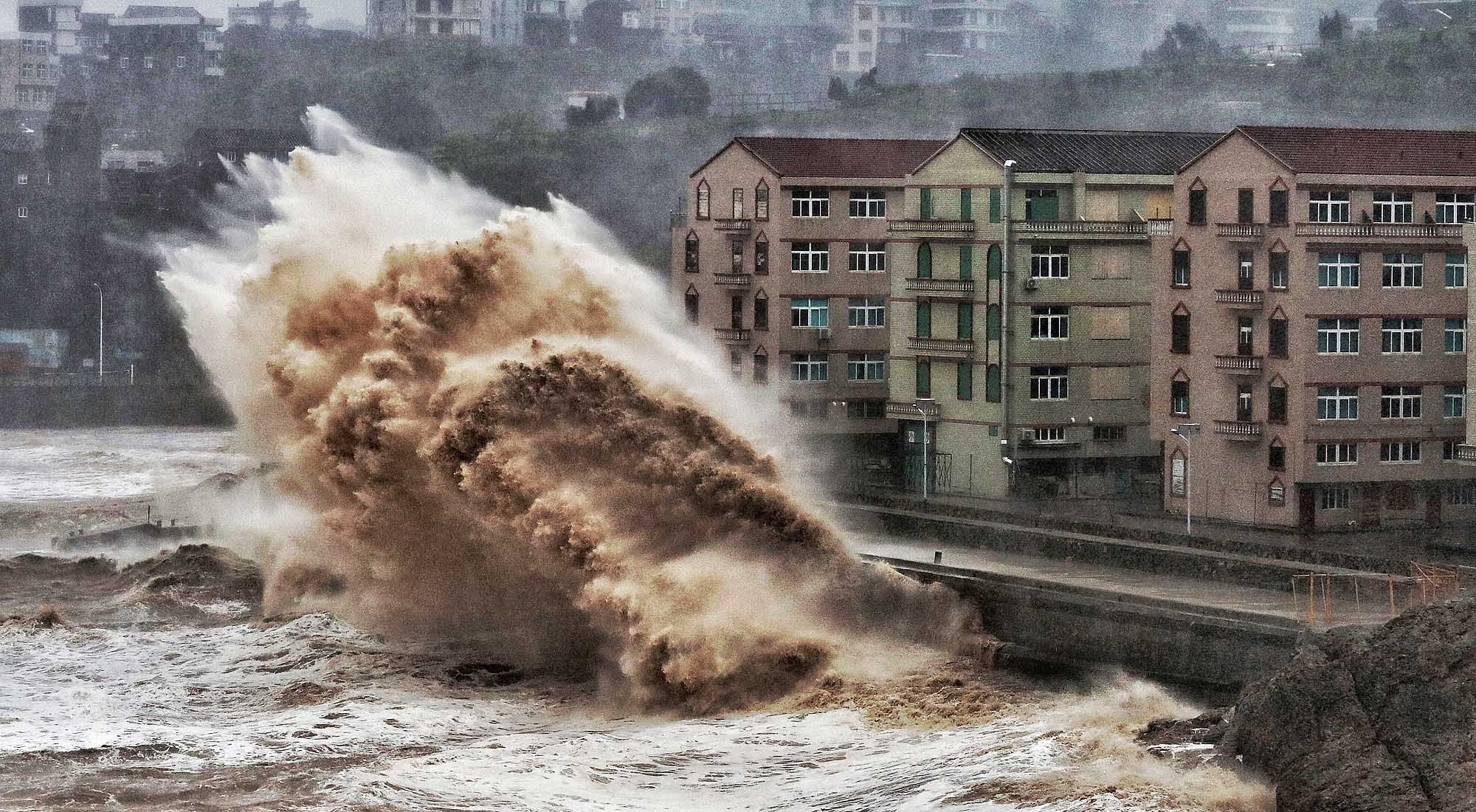 En esta foto de archivo tomada el 9 de agosto de 2019, las olas golpean una pared del mar frente a edificios en Taizhou, en la provincia oriental china de Zhejiang. - 