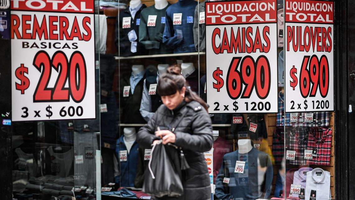A woman walks past a store offering discounts in the capital.