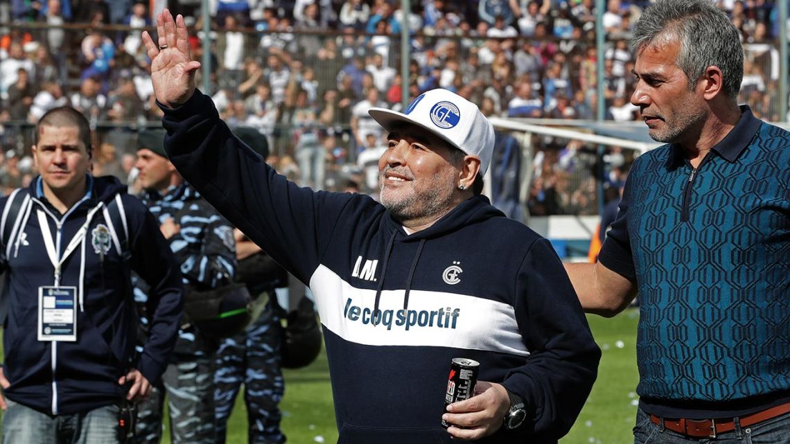 Diego Maradona waves next to Gimasia Club President Gabriel Pellegrino (right), during the first training session of the team with him as coach at the El Bosque stadium, in La Plata, Buenos Aires Province.
