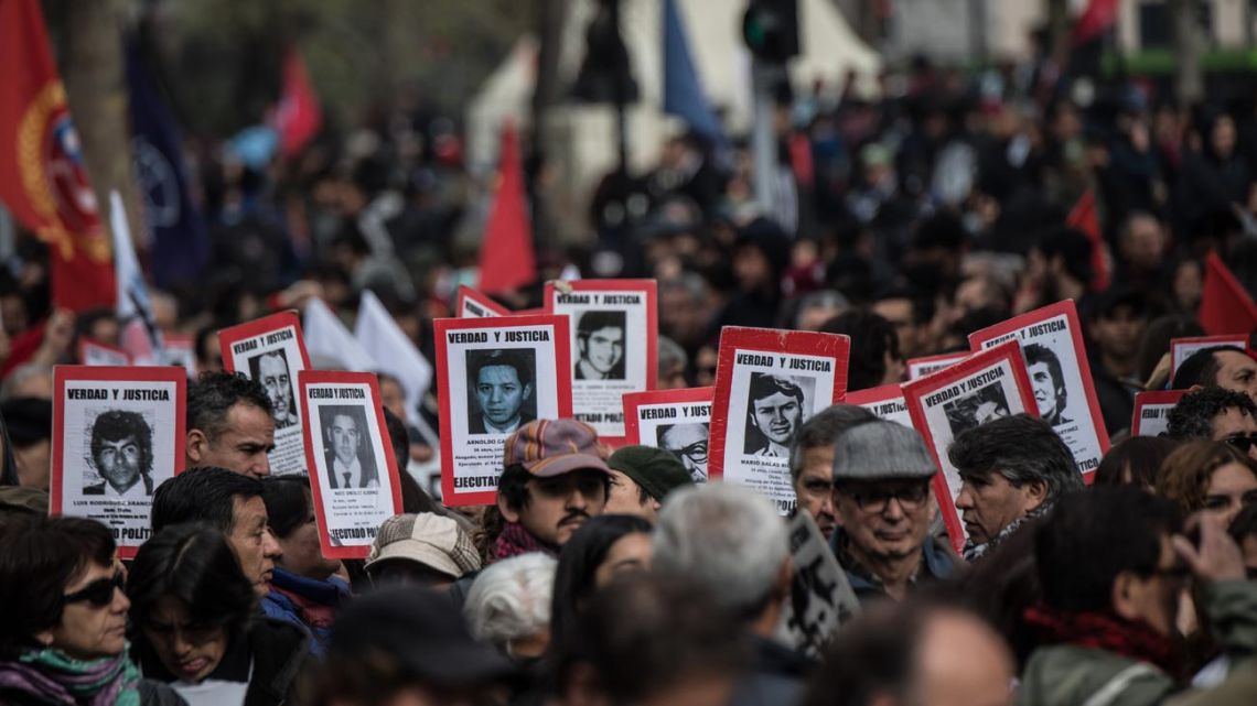 Chilean Human Rights organisation "Detained and Disappeared People" activists hold portraits of people disappeared during the military dictatorship (1973-1990) during a rally commemorating the upcoming anniversary of the military coup led by General Augusto Pinochet that deposed President Salvador Allende, in Santiago, on September 8, 2019. 