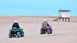 Un grupo avanza sobre los médanos de Gesell camino al faro. Nuevas reglas se imponen en este y otros balnearios.
