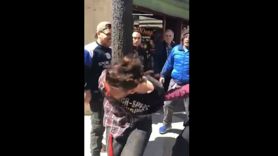 Uno de los ladrones detenido por los vecinos y esposado por una policía.