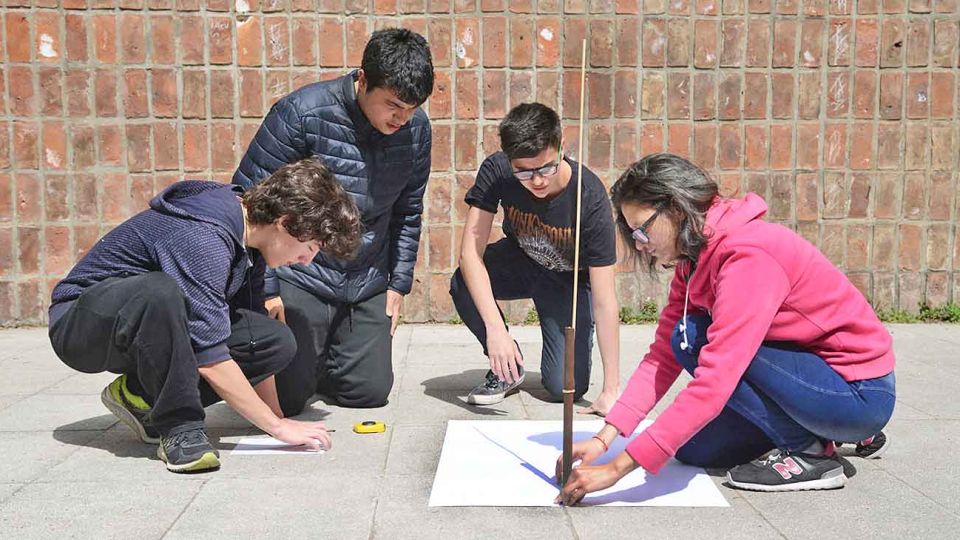 Manos a la obra. Uno de los grupos de estudiantes en el patio del colegio haciendo mediciones de la sombra que proyecta el Sol.