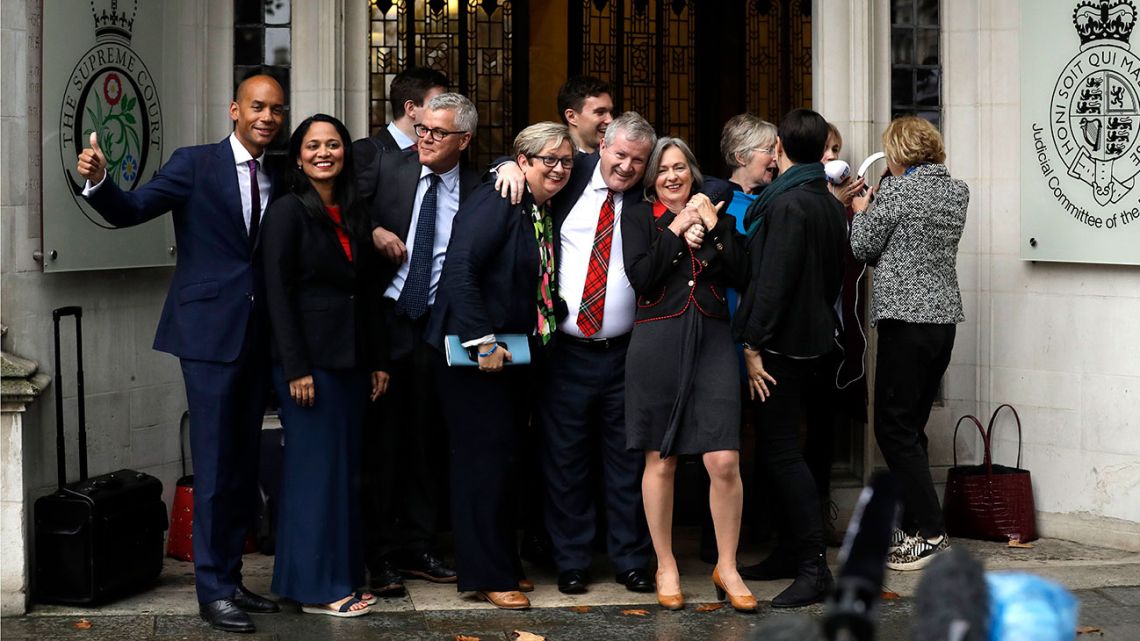 Anti-Brexit campaigners gather outside the Supreme Court in London, Tuesday, Sept. 24, 2019 after it made it's decision on the legality of Prime Minister Boris Johnson's five-week suspension of Parliament. In a setback for Johnson, Britain's Supreme Court has ruled that the suspension of Parliament was illegal. The ruling Tuesday is a major blow to the prime minister who had suspended Parliament for five weeks, claiming it was a routine closure. 