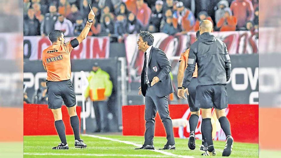 Espalda. Merlos amonesta a Gallardo. Después le cobró a Vélez un penal inexistente.
