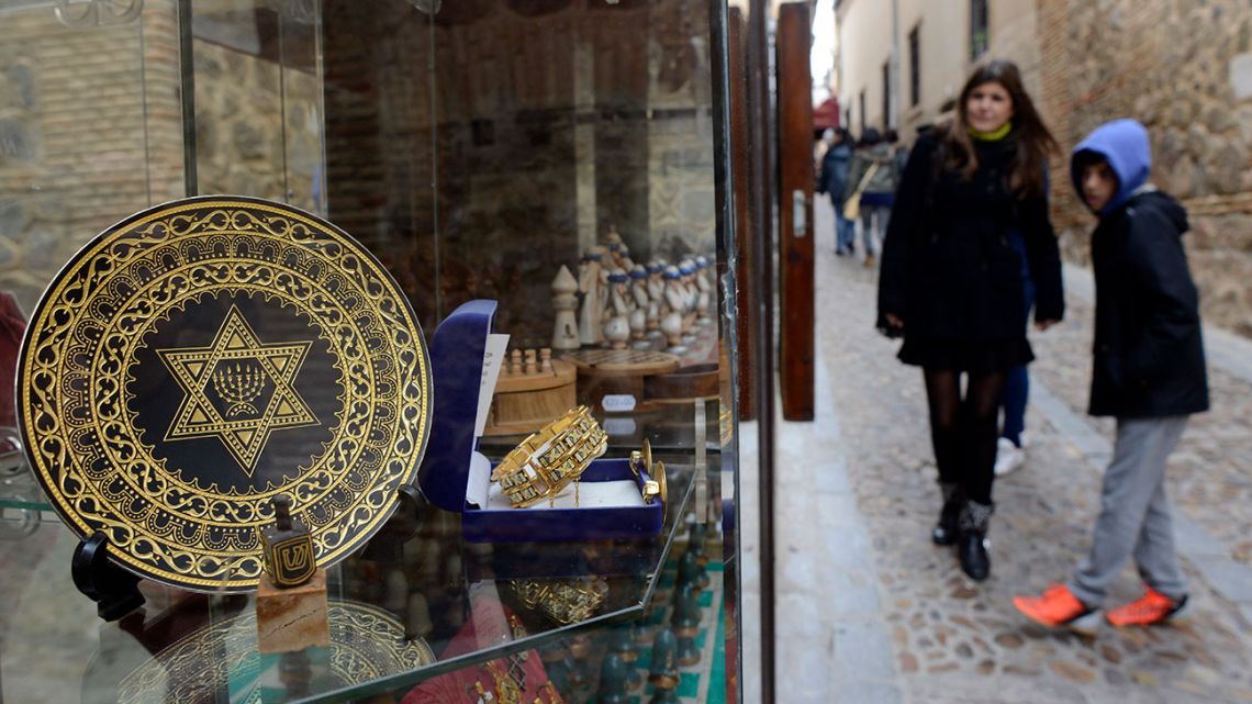 People stand near a gift shop in the old Jewish Quarters of Toledo.