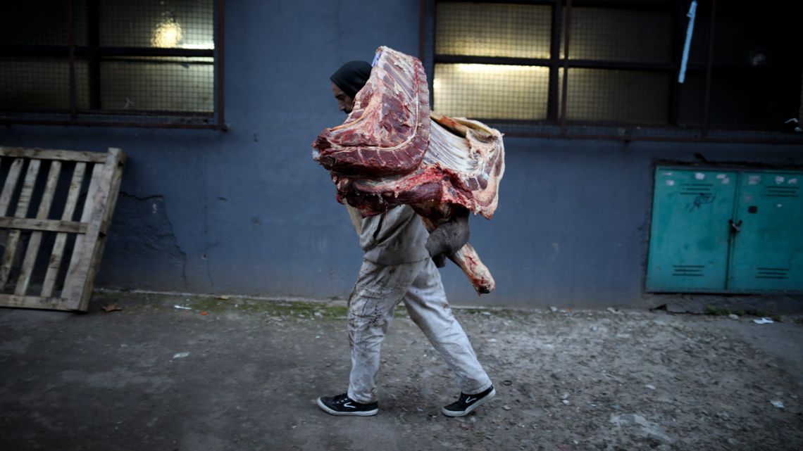 A butcher carries meat to his shop in Buenos Aires.