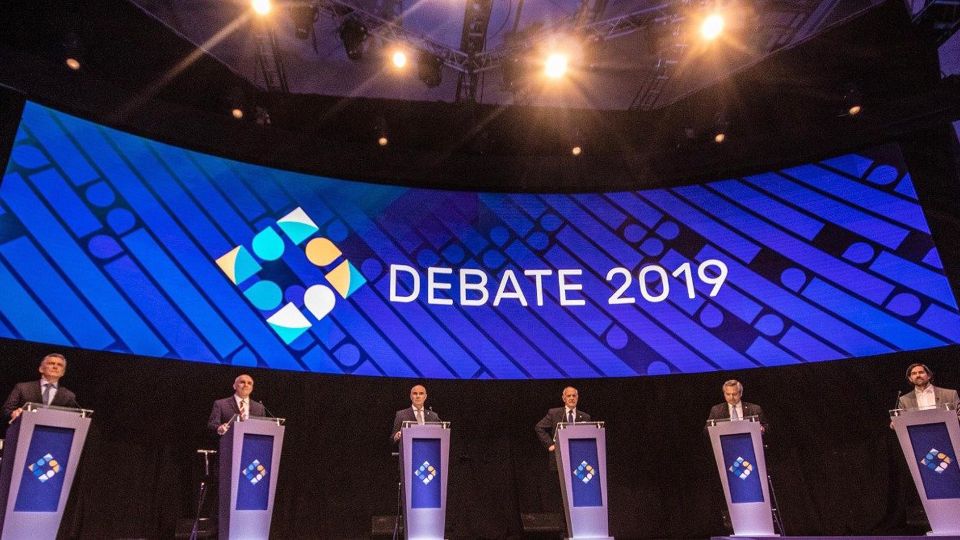 Los candidatos en el escenario debaten sus propuestas.