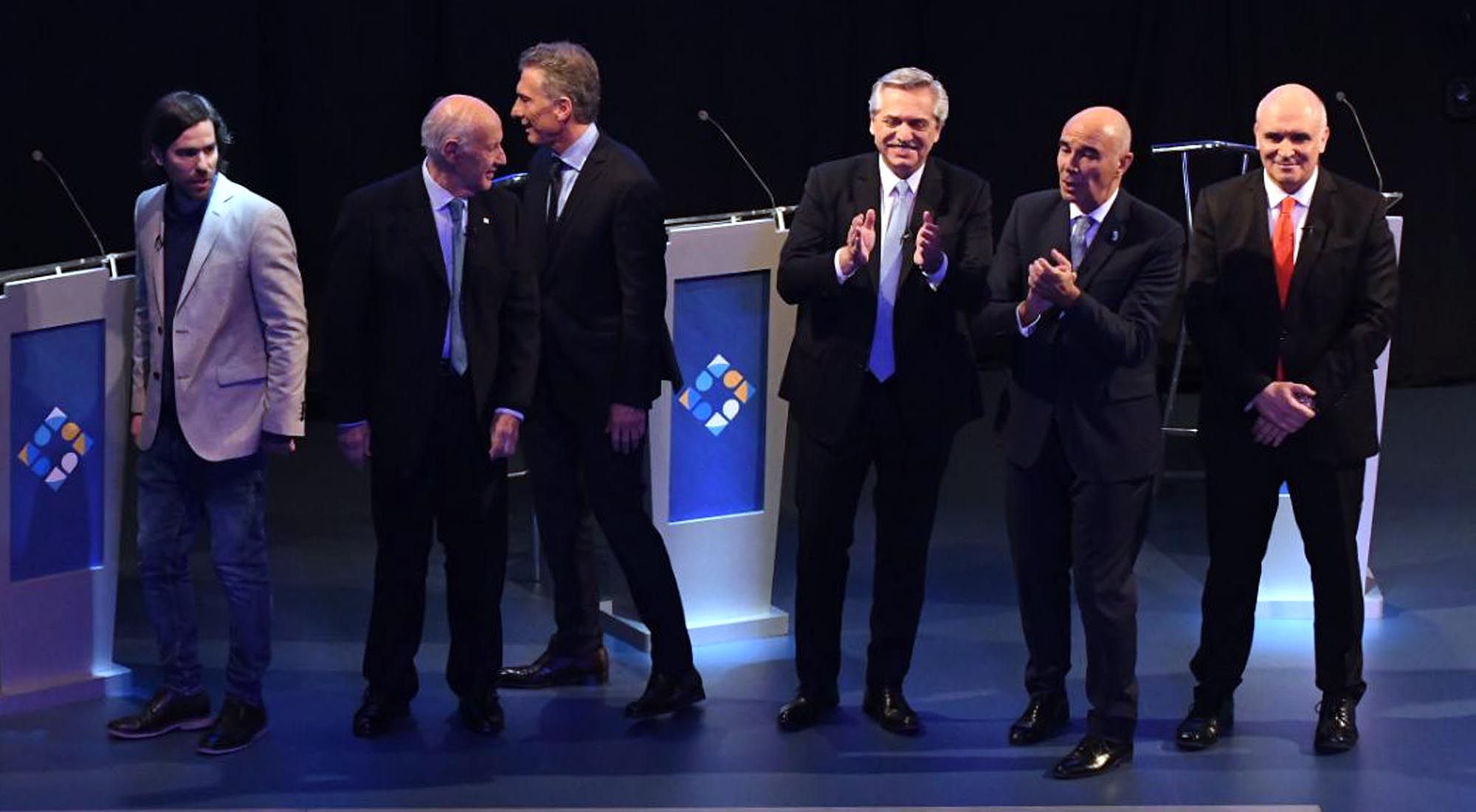 Los candidatos se despiden después de concluir con el debate.