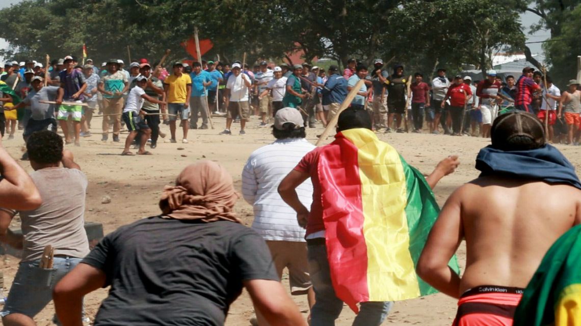 Supporters (background) of Bolivian President and presidential candidate Evo Morales, and supporters of opposition presidential candidate Carlos Mesa clash in La Guardia, Bolivia after Sunday's election.