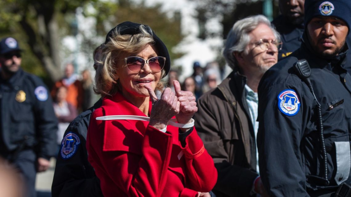 Actress Jane Fonda gestures after being arrested bring a rally on Capitol Hill in Washington. 