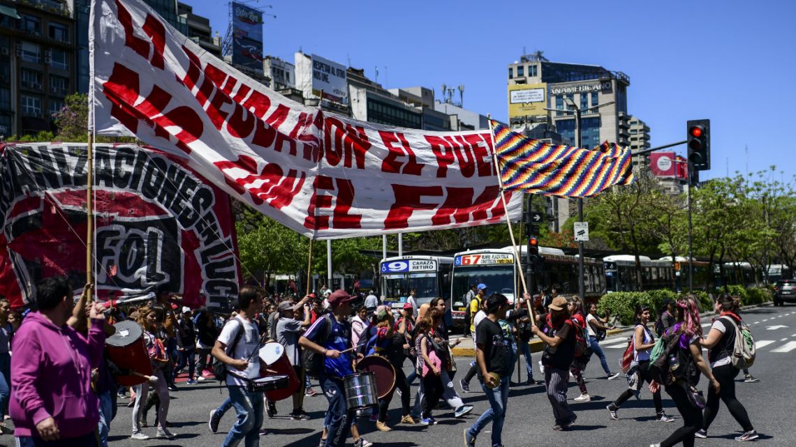 People march towards the International Monetary Fund (IMF) offices in Buenos Aires, on October 31, 2019, during the first social protest since Argentina's president-elect Alberto Fernandez won the South American country's presidential election. 
