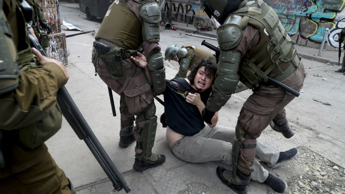 Police detain a demonstrator during an anti-government protest in Santiago
