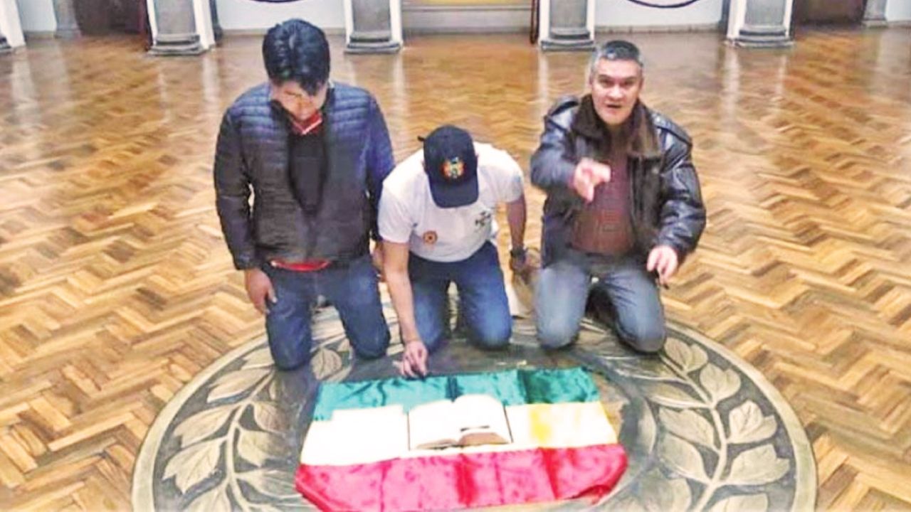 Luis Fernando Camacho colocó su escrito sobre una biblia y la bandera boliviana arrodillándose en el piso, en la Casa de Gobierno.  | Foto:Cedoc
