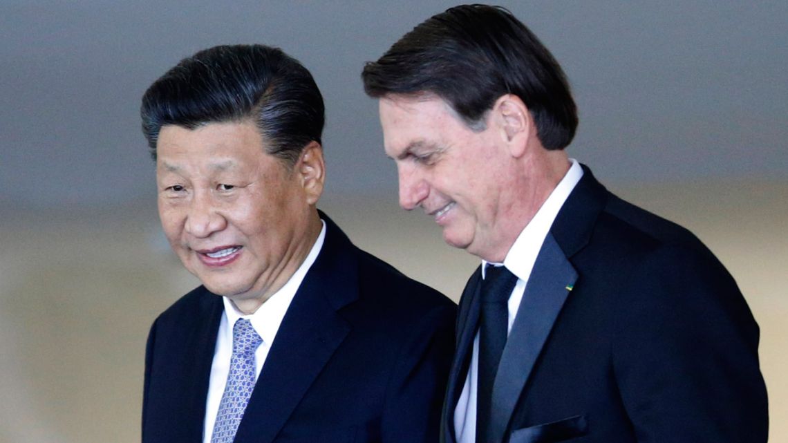 China's President Xi Jinping, left, walks with Brazil President Jair Bolsonaro, upon the Chinese leader's arrival for a bilateral meeting on the sidelines of the 11th edition of the BRICS Summit, at the Itamaraty Palace, in Brasilia, Wednesday, November 13, 2019.