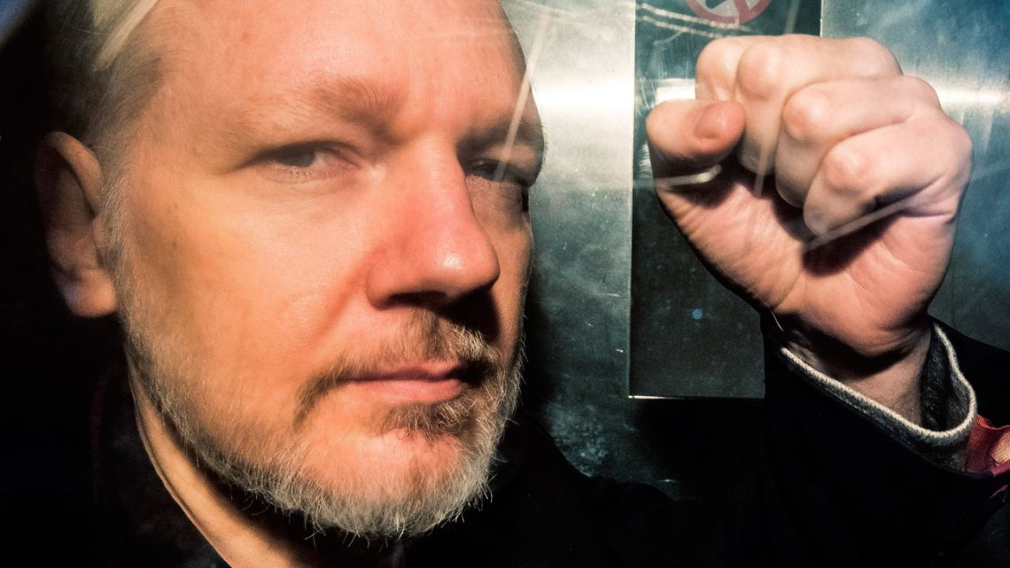This file photo taken on May 1, 2019 shows WikiLeaks founder Julian Assange gesturing from the window of a prison van as he is driven into Southwark Crown Court in London, before being sentenced to 50 weeks in prison for breaching his bail conditions in 2012.
