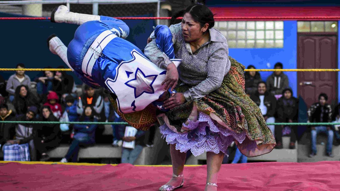 Bolivian wrestler Ana Luisa Yujra (R), aka "Jhenifer Two Face", a member of the Fighting Cholitas, fights with a male wrestler at Sharks of the Ring wrestling club in El Alto, Bolivia, on November 24, 2019. After a fortnight hiatus due to anti-government protests and blockades, the Fighting Cholitas are back in the ring. The unrest was triggered by the disputed October 20 election, which Evo Morales claimed to have won and opposition groups said was rigged.