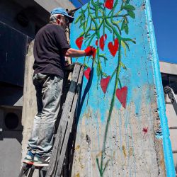 El fragmento del Muro de Berlín es intervenido por el artista y director de Arte de Editorial Perfil, Pablo Temes. | Foto:Facundo Iglesias