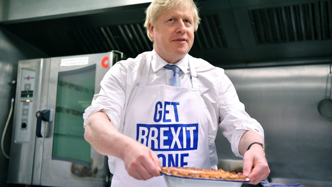 Britain's Prime Minister Boris Johnson prepares a pie at the Red Olive catering company while on the campaign trail, in Derby, England