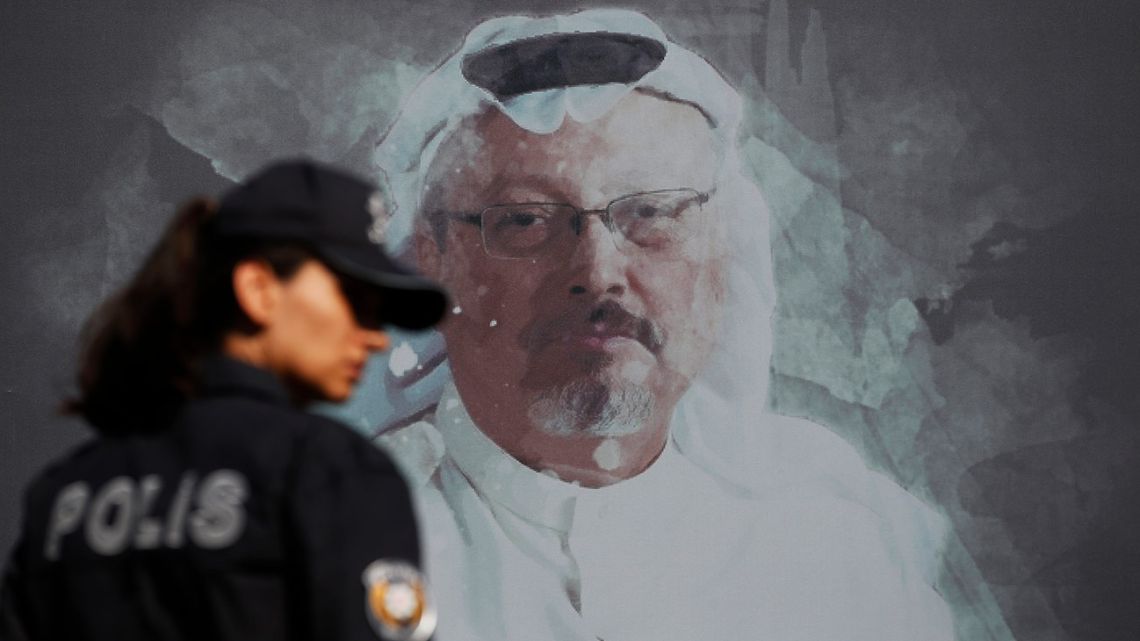 A Turkish police officer walks past a picture of slain Saudi journalist Jamal Khashoggi prior to a ceremony, near the Saudi Arabia consulate in Istanbul, marking the one-year anniversary of his death.