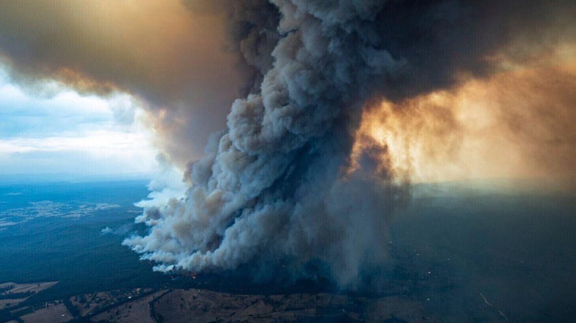 In this image released Thursday, January 2, 2020, from the Department of Environment, Land, Water and Planning in Gippsland, Australia, a massive smoke rises from wildfires burning in East Gippsland, Victoria. Thousands of tourists are fleeing Australia's wildfire-ravaged eastern coast ahead of worsening conditions as the military started to evacuate people trapped on the shore further south. Cooler weather has aided firefighting and allowed people to replenish supplies. 