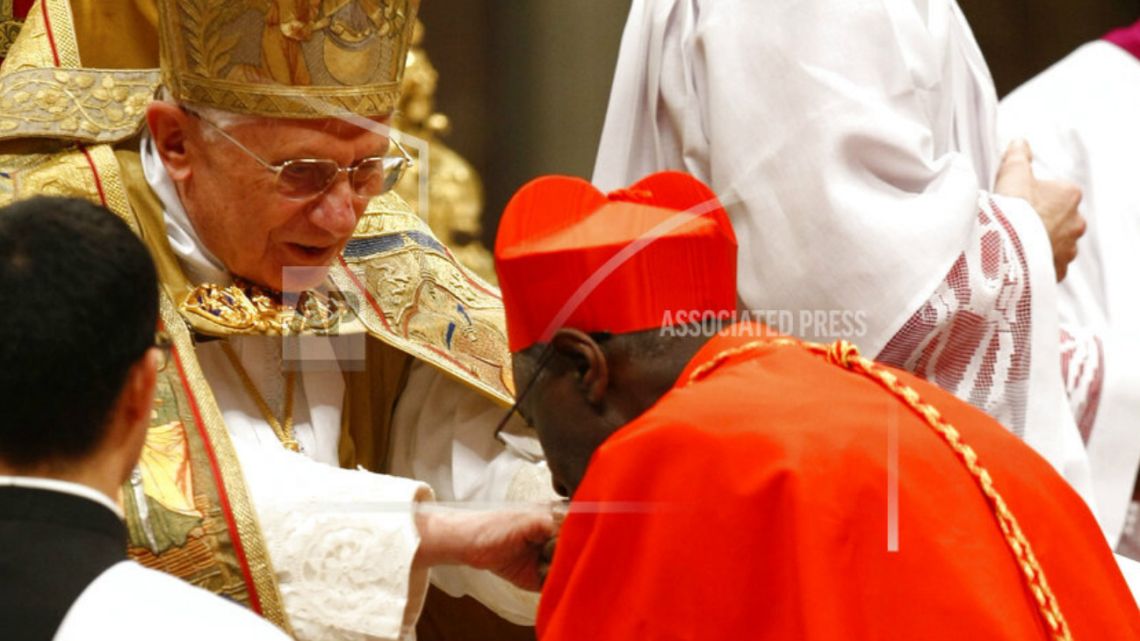 Cardinal Robert Sarah, right, kisses Pope Benedict XVI's hand