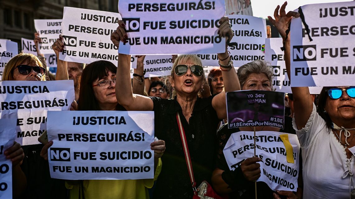 People hold up signs during a protest marking the commemoration of the fifth anniversary of the death of special prosecutor of the AMIA case, Alberto Nisman, on January 18, 2020, in Buenos Aires. 