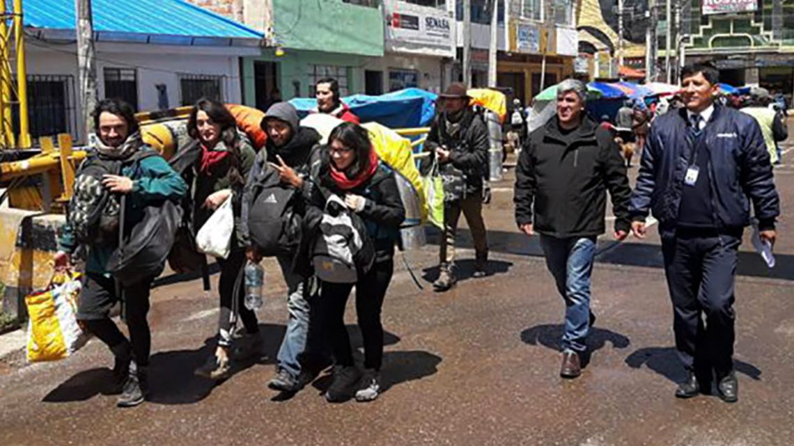 Handout photo distributed by the Peruvian Migrations Service of tourists being escorted by authorities as they walk towards the borderline with Bolivia.