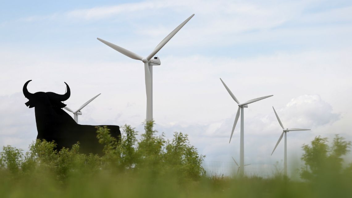 This file photo taken on May 10, 2016 shows an "Osborne" bull in front of wind turbines at the La Plana, near Zaragoza in Spain.