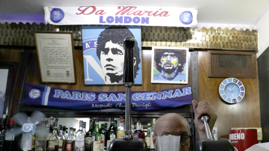 A bartender prepares an espresso coffee inside the Bar Nilo where a makeshift shrine of soccer legend and former Napoli player Diego Armando Maradona is displayed, in downtown Naples, Italy, Wednesday, September 18, 2019.