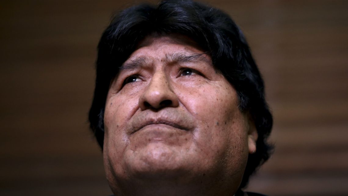 Bolivia's former President Evo Morales looks up as his lawyers speak during a press conference regarding the rejection of his plan to run for Senator.
