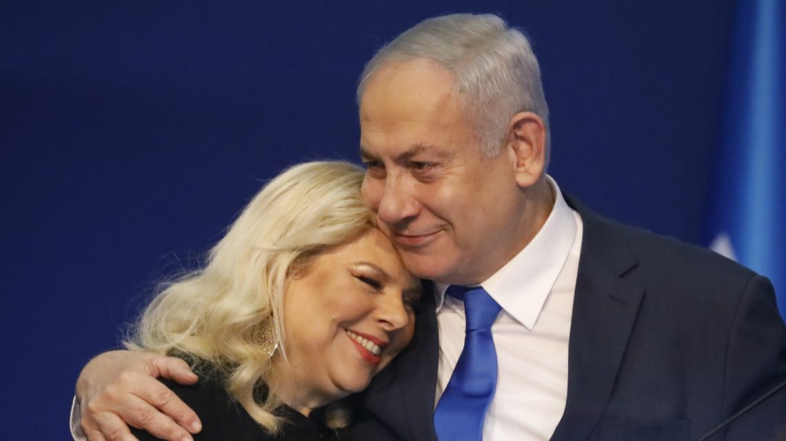 Israeli Prime Minister Benjamin Netanyahu hugs his wife Sara after first exit poll results for the Israeli elections at his party's headquarters in Tel Aviv.