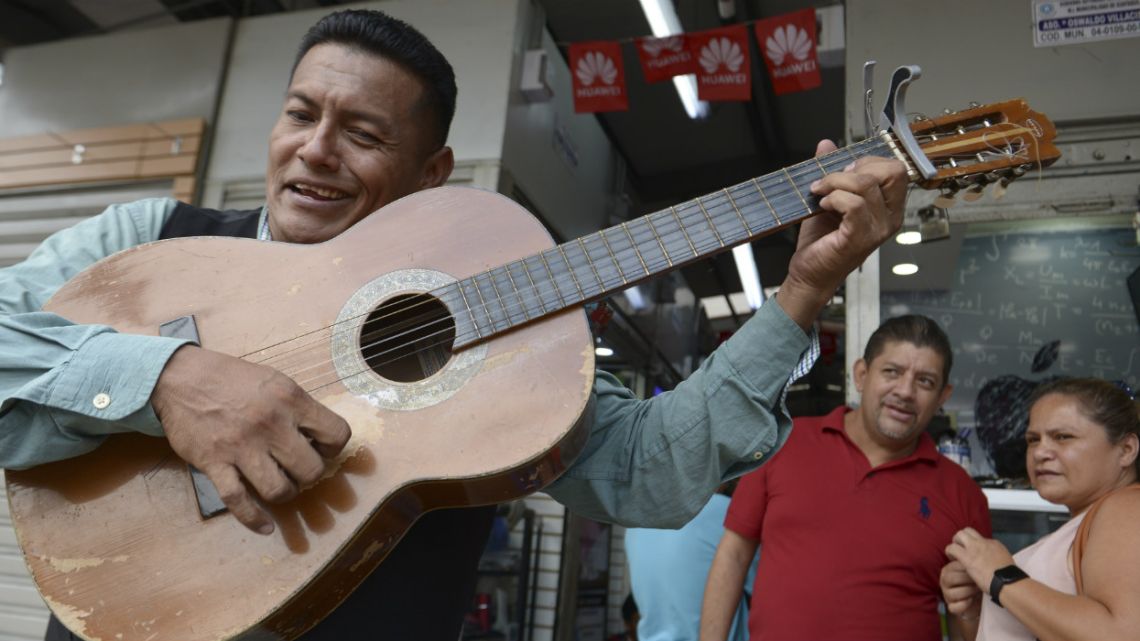 Street musician Angel Alvarado, known as "Allan El Trovador," sings his "coronavirus" song at a market in Guayaquil, Ecuador.