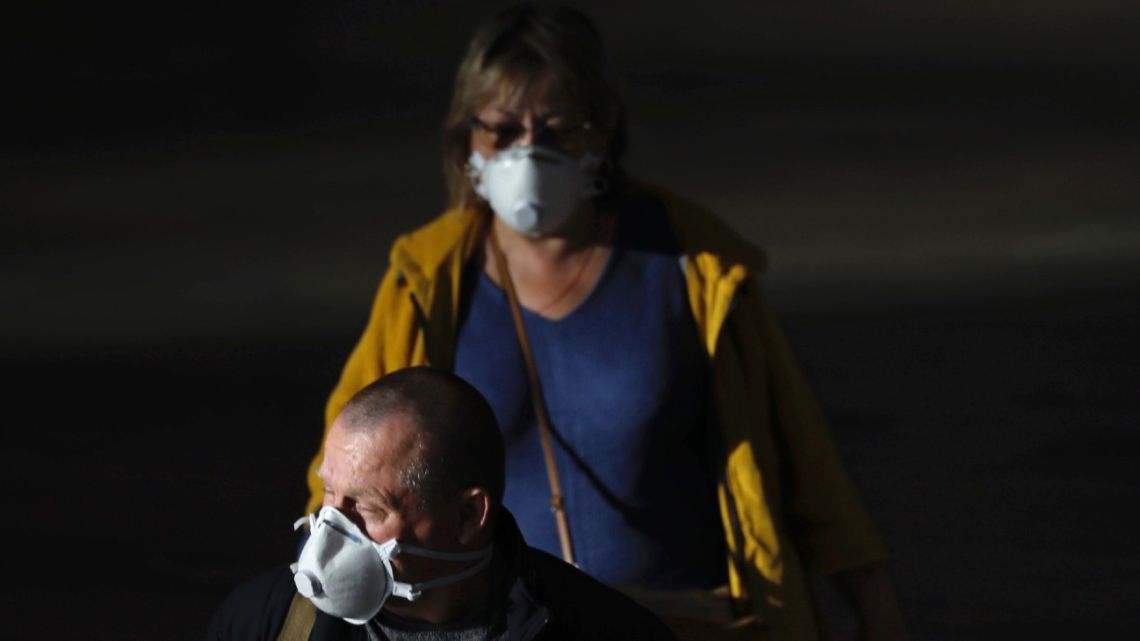 Passengers wear masks to help protect against coronavirus, at the Ben Gurion airport near Tel Aviv, Israel, Sunday, March 8, 2020.