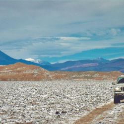 Los vehículos cruzan el Salar de Antofalla, rumbo a Inca Huasi; detrás, el volcán Peinado. 