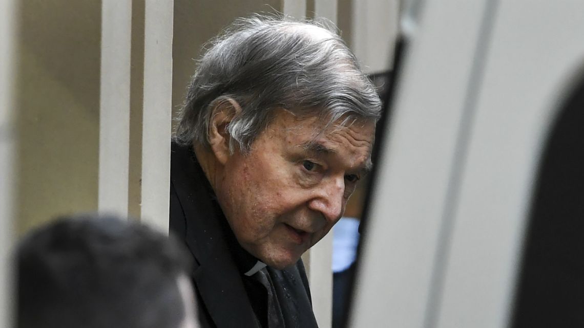 In this file photo taken on August 21, 2019, Australian Cardinal George Pell (C) is escorted in handcuffs from the Supreme Court of Victoria in Melbourne.