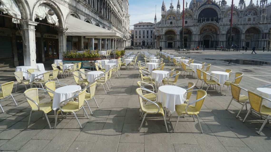 Empty chairs and tables are lined up outside a restaurant in St. Mark's Square in Venice, Italy.