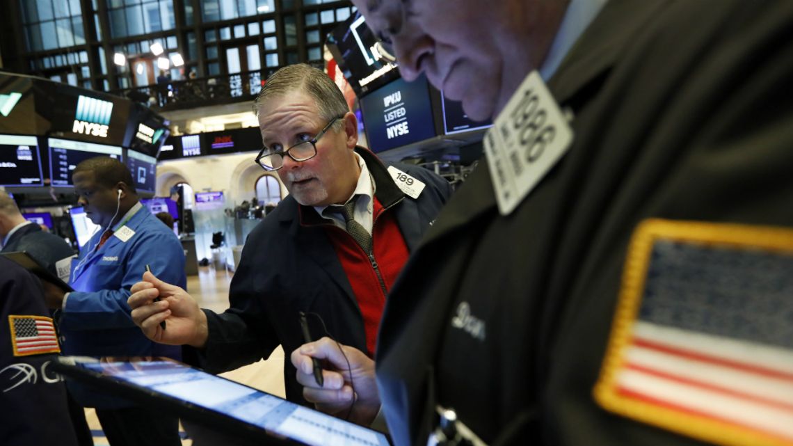 Trader Gregory Rowe, left, and specialist Peter Giacchi work on the floor of the New York Stock Exchange.