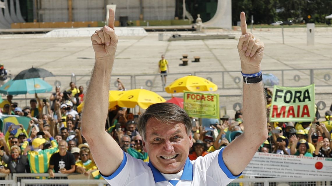 Brazilian President Jair Bolsonaro greets supporters in front of the Planalto Palace, after a protest against the National Congress and the Supreme Court, in Brasilia, on March 15, 2020.