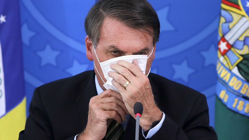 Bolsonaro, con barbijo en conferencia de prensa. Su tibia reacción contra el coronavirus genero criticas y hubo cacerolazos en Brasil.