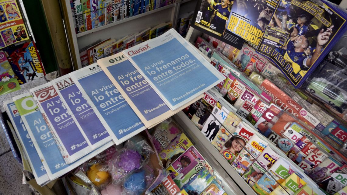 Local newspapers with the same front page reading "We stop the virus among all" are displayed at a kiosk during the outbreak of the new Coronavirus, COVID-19, in Buenos Aires, on March 19, 2020.