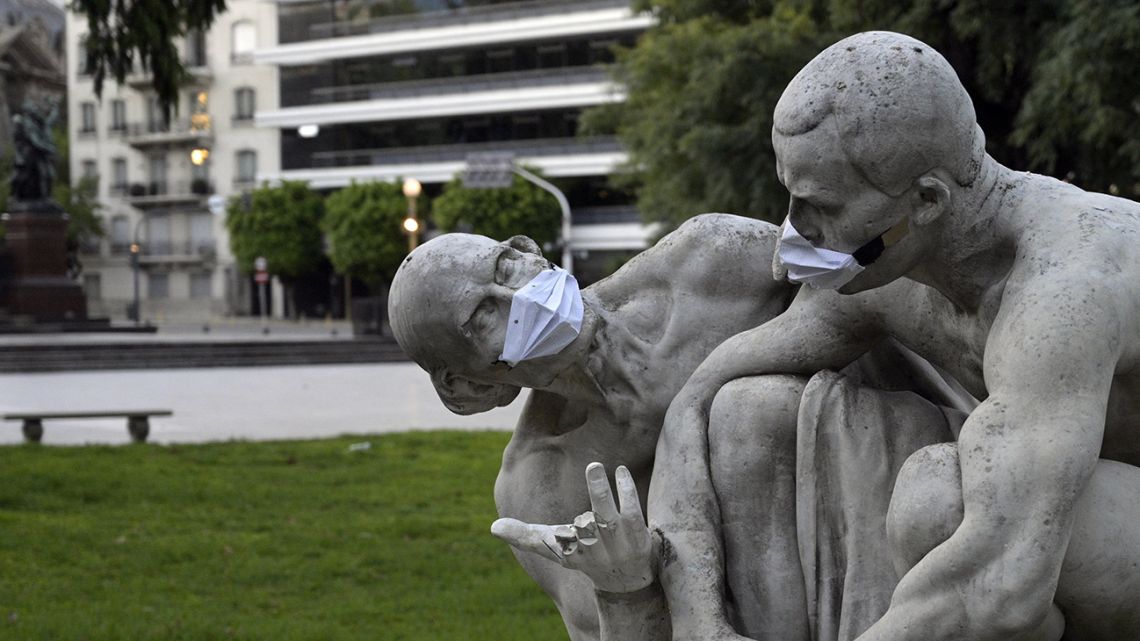 Two statues, dressed with face masks by members of the public, pictured in Buenos Aires.