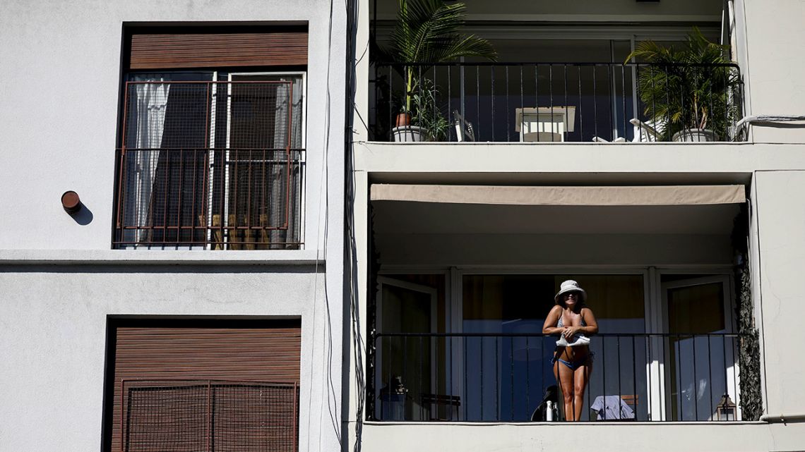 A woman stands on her balcony in Buenos Aires, Monday, March 23, 2020. The government has ordered a forced lock down until the end of the month to help contain the spread of the new coronavirus. 