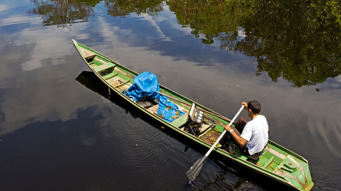 Eder Rodrigues do Nascimento paddles on a boat along the Jurura River in Carauari municipality, Amazonas state, Brazil.